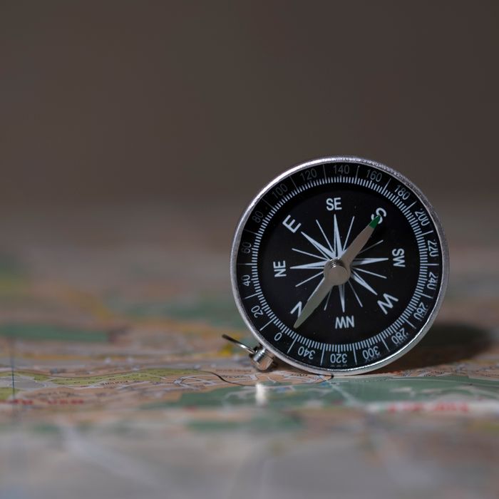 A detailed image of a compass on a map, symbolizing navigation and exploration.